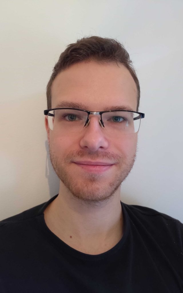 Portrait of a person in a pink sweater against a light background