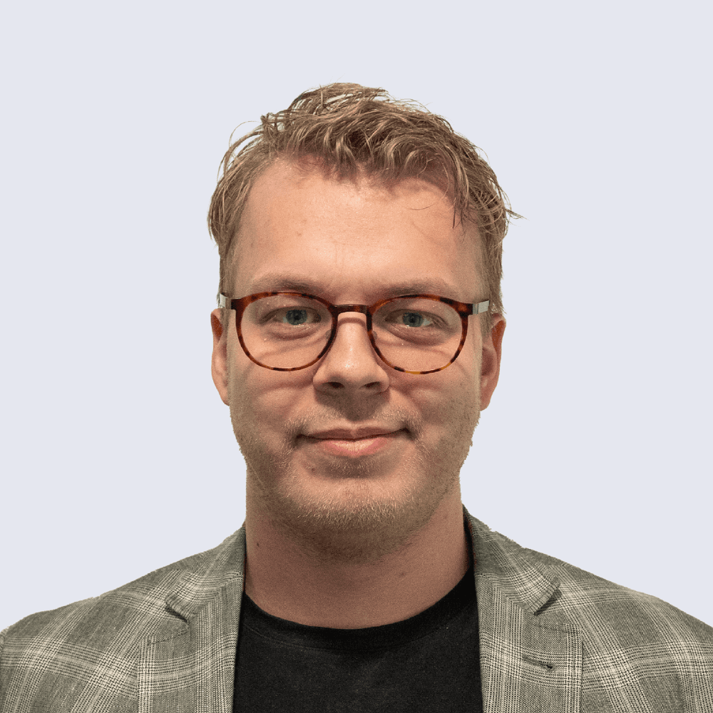 Portrait of a laughing person with curly hair wearing a white shirt